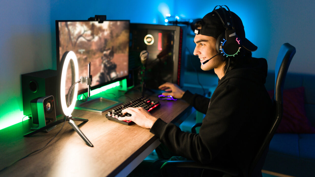 Smiling,young,man,live,streaming,his,online,video,game,using